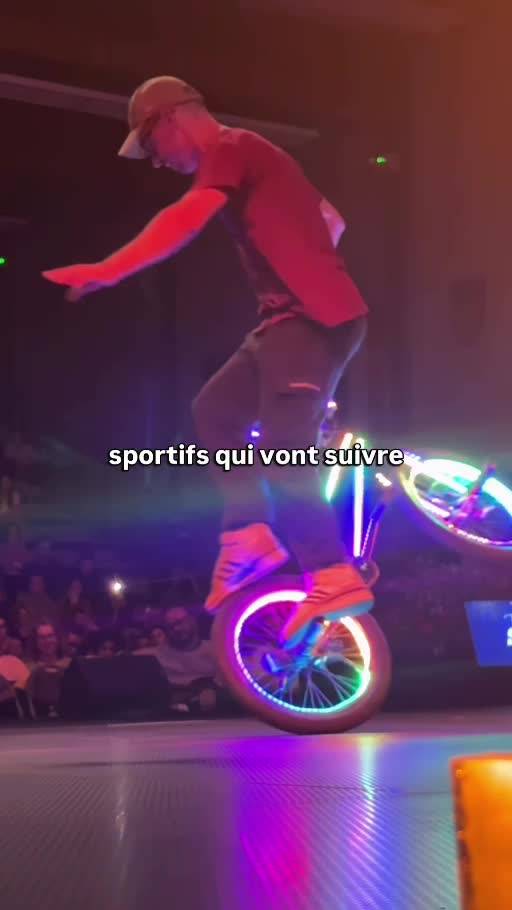 Kevin Meyer en équilibre sur un BMX aux roues lumineuses pendant son spectacle à Mâcon